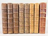plusieurs vieux livres sont alignés sur une surface blanche