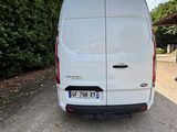 the rear end of a white van parked on the side of a road