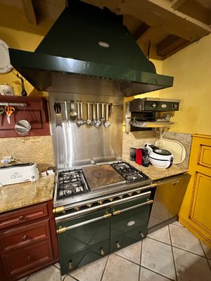 a kitchen with a stove, oven, sink, and cabinets