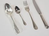 silverware on a white table with a knife, fork, spoon and spoon rest