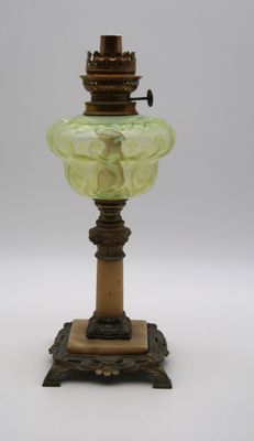une photo d'une lampe en verre vert posée sur un socle en bois