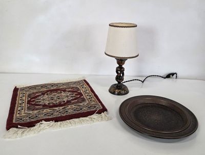 une table sur laquelle se trouvent une assiette, une lampe et un tapis