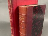 un vieux livre à la couverture rouge posé à côté d'un livre rouge