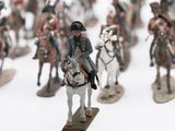 many figurines of people riding horses on a white surface