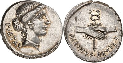 a silver coin with a woman ' s head and hands on it