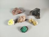 several different colored rocks are arranged on a white surface