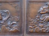 des sculptures sur la façade d'un bâtiment, avec une horloge en arrière-plan