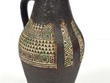 un vase noir et vert orné de motifs géométriques