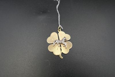 un gros plan d'un collier orné d'un trèfle à quatre feuilles