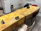une longue table avec des chaises et un réfrigérateur dans la pièce