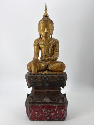 statue d'un Bouddha assis sur une caisse en bois