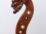 un gros plan d'un violon avec une tête gravée sur le dos