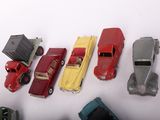 several toy cars are lined up in a row on a white surface