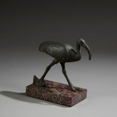 bronze statue of a bird on a stone base