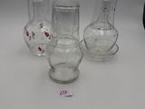 three clear glass vases sitting on top of a white table