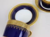 two cups and a saucer on a white table