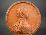 a close up of a bronze medallion with a woman ' s face