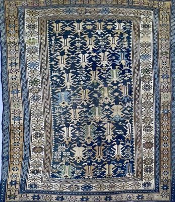 a blue rug with a design of flowers and leaves on it