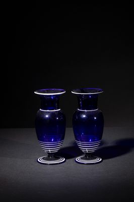 two blue glass vases sitting on a table