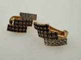 a pair of black and white diamond earrings on a white surface