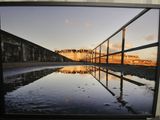 a picture of a reflection of a bridge in the water