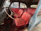 an old car with red leather seats and a steering wheel