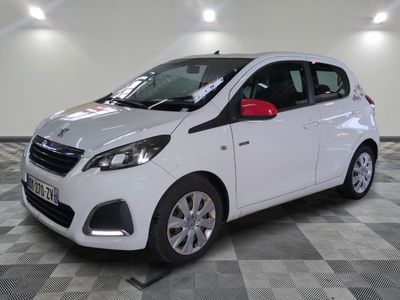 the small white car is parked on a checkered tile floor