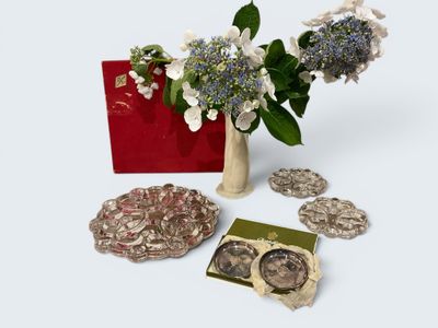 a vase with flowers and coins in it next to a red box