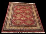 un tapis rouge et or à franges sur fond noir