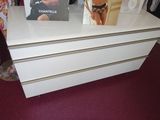 a white chest of drawers with a magazine on top of it