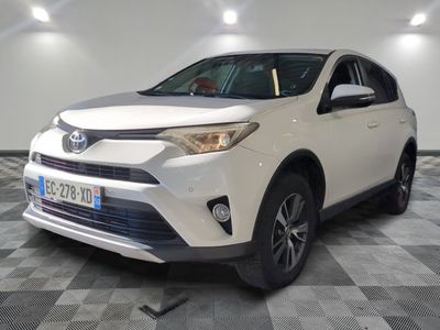 La Toyota RAV blanche est garée dans une grande pièce.
