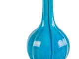 un vase bleu posé sur une surface blanche