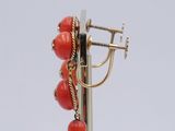 a close up of a pair of earrings on a metal pole