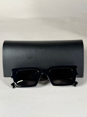 une paire de lunettes de soleil noires posée sur un étui noir