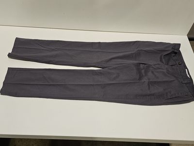 un pantalon gris posé sur une table blanche