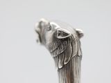 a close up of a silver statue of a dog on a stick