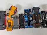 several toy cars are lined up in a row on a white surface