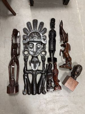 de nombreuses sculptures en bois posées par terre à côté d'une chaise