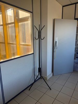 a room with a door, a window, and a tripod in it