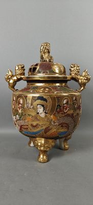 un vase doré et rouge muni d'un couvercle
