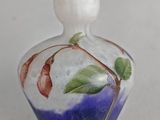 a small glass bottle with a flower on it