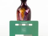 a small vase that is sitting on top of a green card