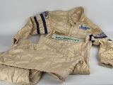 une petite veste et des mitaines posées sur une table blanche