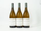 trois bouteilles de vin posées sur une table blanche