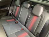 the back seats of a car with red stitching on the seats