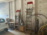a car parked in a garage next to a bunch of ladders