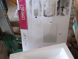 un lavabo blanc posé devant un carton posé par terre