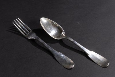 deux cuillères et une fourchette posées sur une surface noire