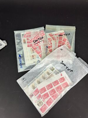 quatre sachets de timbres posés sur une table à côté d'un téléphone portable