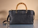 a black purse with bamboo handles sitting on a table